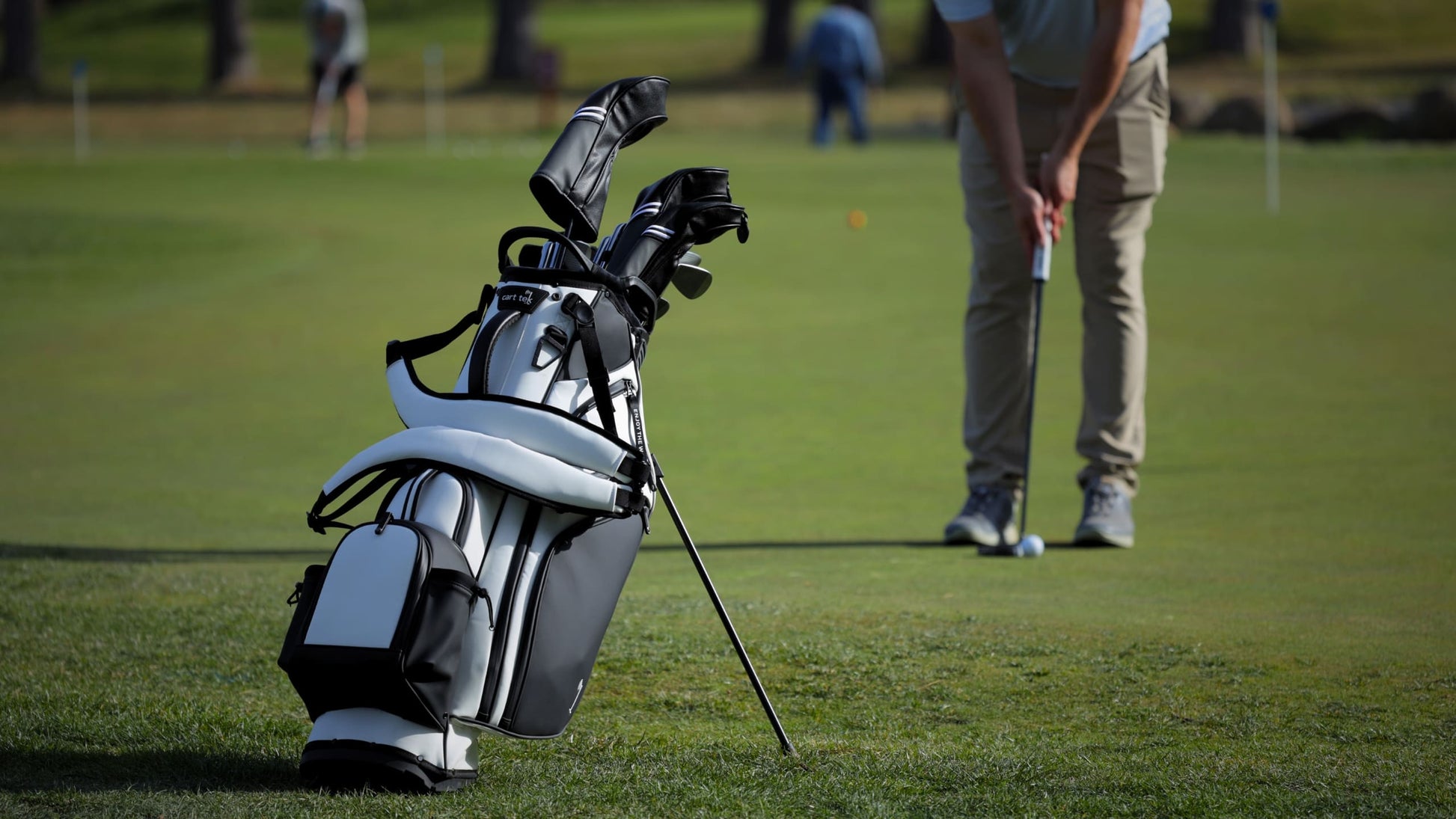 Premium golf cart bag with 14-way divider and ample storage shown on practice green—ideal for electric push carts and walkers.