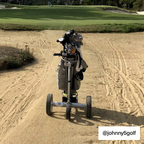 silver electric golf trolley driving through sand bunker GRi-1500li