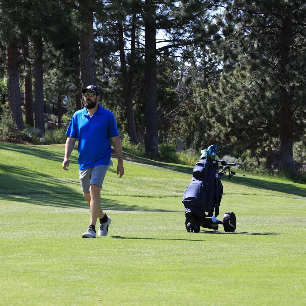 Hands-free electric golf caddy following a golfer walking the course