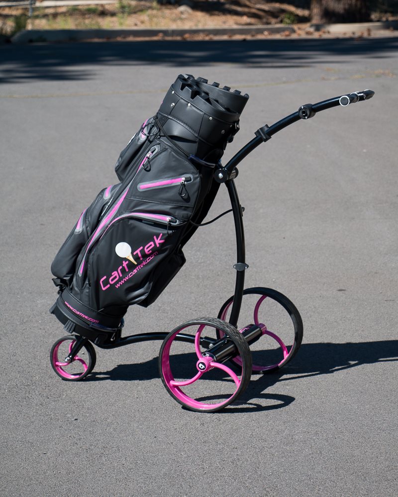 Black Cart-Tek GRI-975Li battery powered electric golf trolley with pink wheels and golf bag